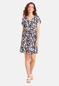 Kleid mit kurzen Ärmeln in Marineblau und Creme mit einem Blattmuster, das über einen V-Ausschnitt und eine geraffte Taille mit einem gebundenen Gürtel verfügt. Glattes, leichtes Material.