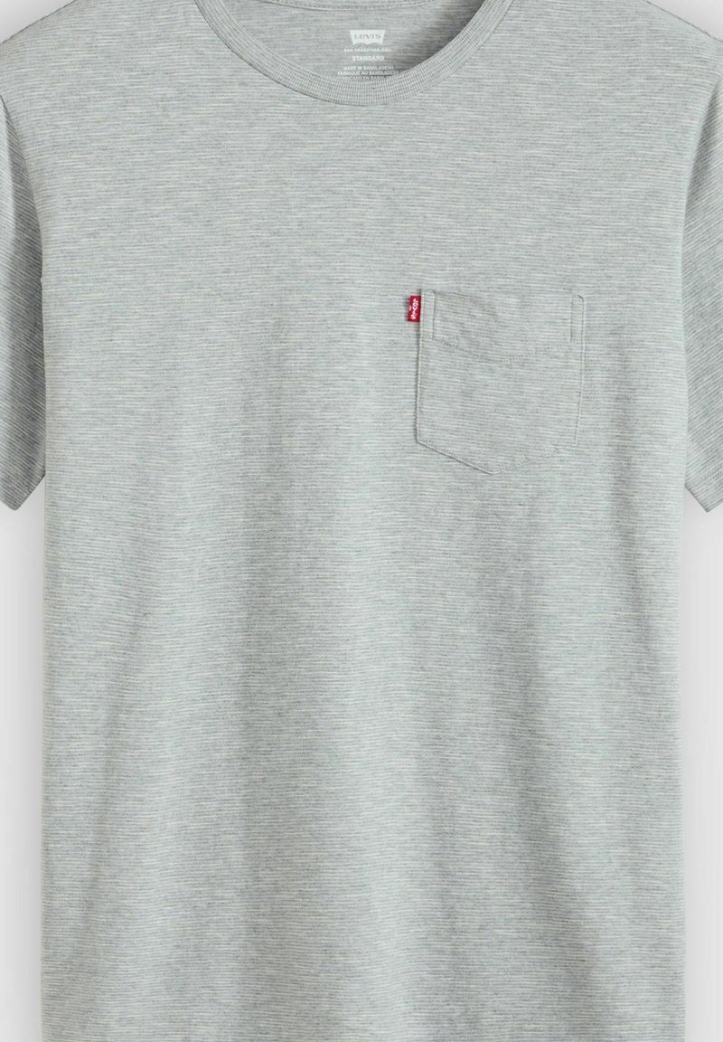 T-shirt gris clair à manches courtes avec une petite poche poitrine et une étiquette rouge Levi’s sur le bord de la poche.