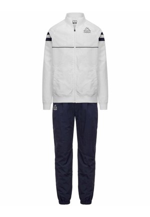 Giacca bianca con zip e strisce nere sulle maniche e pantaloni blu navy, entrambi con logo Kappa sul petto e sulla coscia.