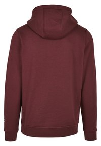 Felpa bordeaux con cappuccio regolabile, maniche lunghe e polsini a costine. Realizzata in un tessuto morbido con una texture liscia, presenta un logo sulla manica.