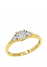 Guld ring med en central rund diamant, flankeras av två mindre diamanter, med en polerad ring och intrikata klor.