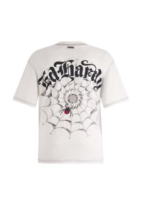 Kortærmet, lysefarvet t-shirt med et sort spidsevævsgrafik og en rød edderkop samt en fed tekstdesign på ryggen.