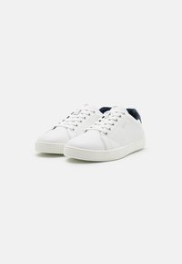 Weisse Leder-Sneaker mit niedrigem Profil, runder Zehenpartie, kontrastierendem navyfarbenem Fersenbereich und flacher, weisser Gummisohle; verfügen über ein Schnürdesign und Logodetail.
