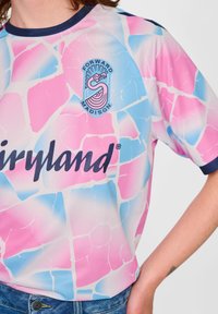 Kurzarmhemd in Pink, Blau und Weiß mit einem Mosaikmuster. Mit einem marineblauen Kragen und dem Logo "Forward Madison" sowie dem Text "Fairyland".