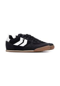Zapatos deportivos negros con rayas blancas, con una parte superior texturizada, punta redonda y suela de goma. Diseñados con una silueta elegante.