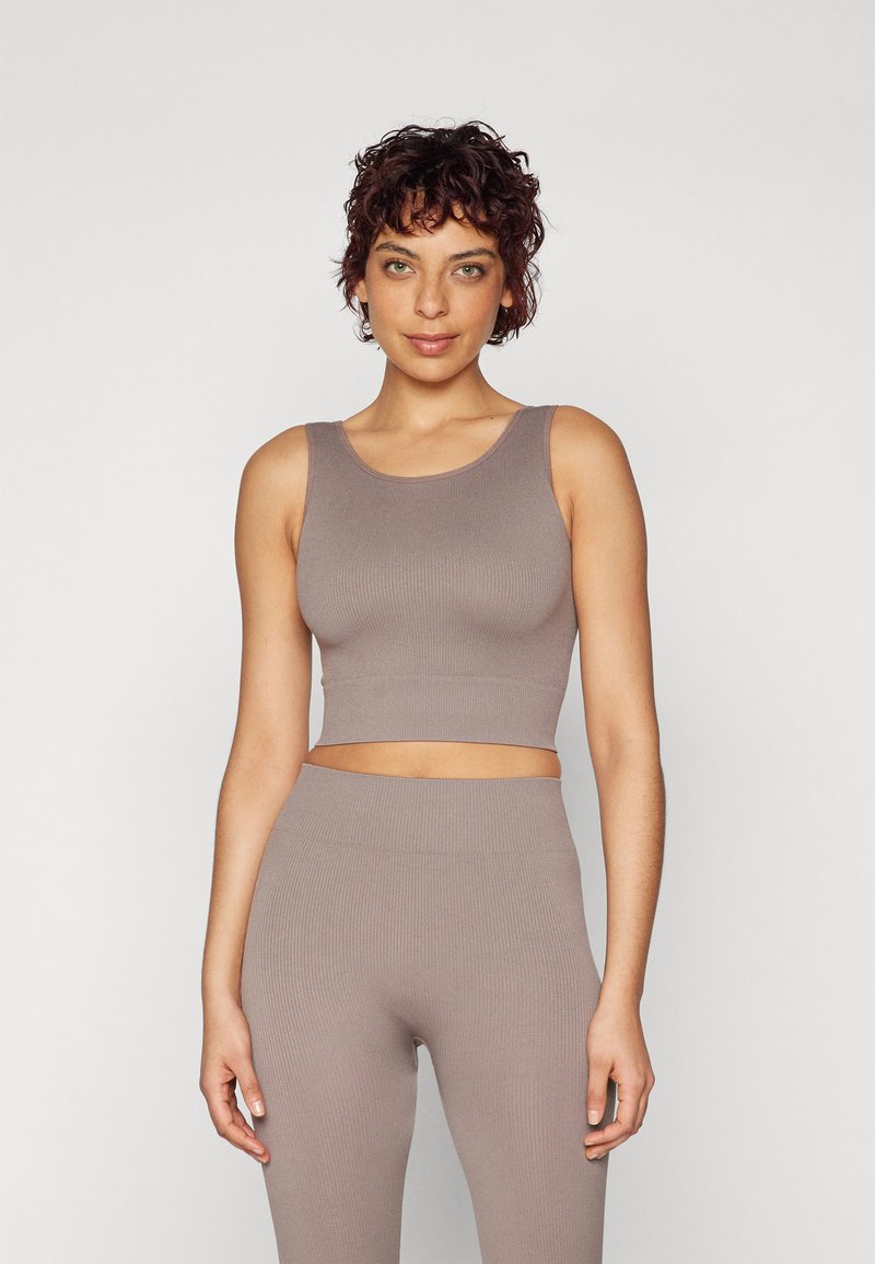 Ribbed crop top and matching high-waisted leggings in a soft taupe color. The fabric has a smooth texture with a snug fit and wide straps.