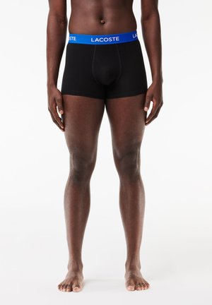Boxer-briefs noirs avec une ceinture en logo Lacoste bleu, offrant un ajustement confortable et en coton lisse. Pas de motifs ou d'accents supplémentaires.