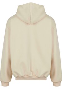 Felpa beige con una texture morbida, cappuccio arrotondato e polsini ed orlo elasticizzati. Presenta una vestibilità comoda con cuciture minime.