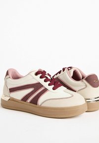 Sneakerid, millel on valgest nahast pealis, bordo- ja helesinised aktsendid, tekstureeritud tallad, ümmargune varvas ja metallik detailid kandadel.