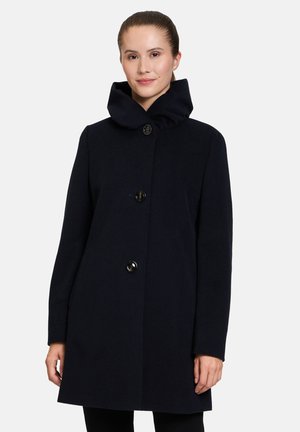 Dark navy coat featuring a high, ruffled collar, three button closures, and a straight silhouette. Made from a soft wool-like fabric.