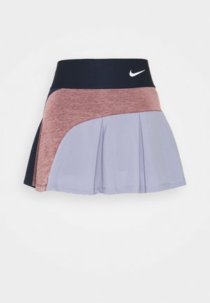 Rock mit schwarzem Bund und weißem Nike-Logo, melierter rosafarbener Mittelteil und hellvioletter, plissierter unterer Abschnitt auf weißem Hintergrund.