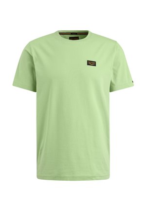 Hellgrünes Baumwoll-T-Shirt mit kurzen Ärmeln, rundem Halsausschnitt und einem kleinen schwarzen Patch mit Text im linken Brustbereich.