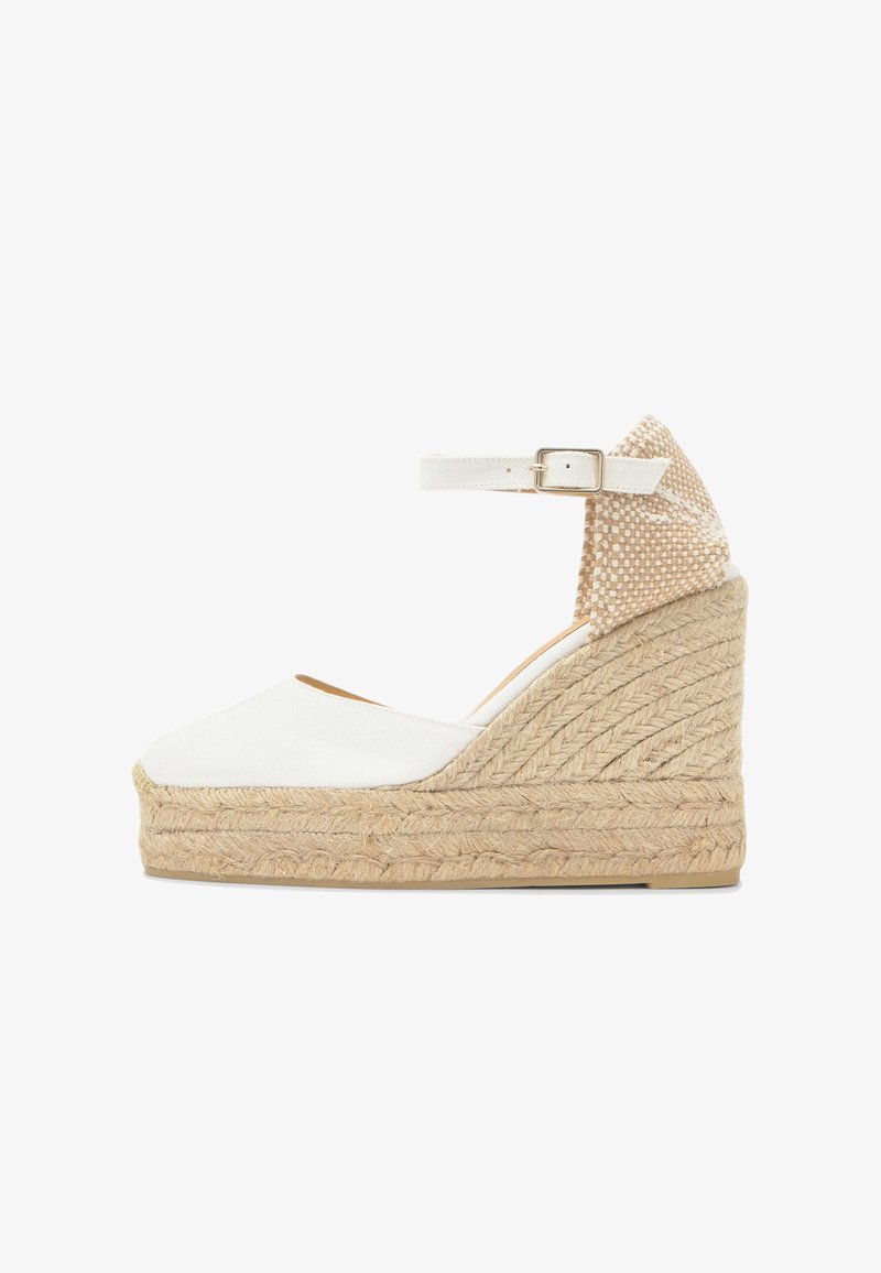 Sandale espadrille compensée blanche avec plateforme en jute tissé, bride à la cheville, boucle dorée et contrefort de talon beige texturé.