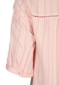 Blusa rosa claro con rayas verticales, mangas cortas con volantes, detalle de botones en el puño y un elaborado acento de encaje cerca del escote.