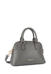 Sac à main en cuir gris avec quincaillerie dorée, double poignée supérieure et une bandoulière amovible, affichant une surface texturée et une forme arrondie.