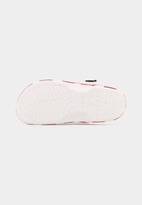 Κόκκινη και λευκή σόλα σανδάλια Crocs, εμφανιζόμενη από κάτω, που αναδεικνύει το σχέδιο πέλματος και τις ενδείξεις μεγέθους 8-10.