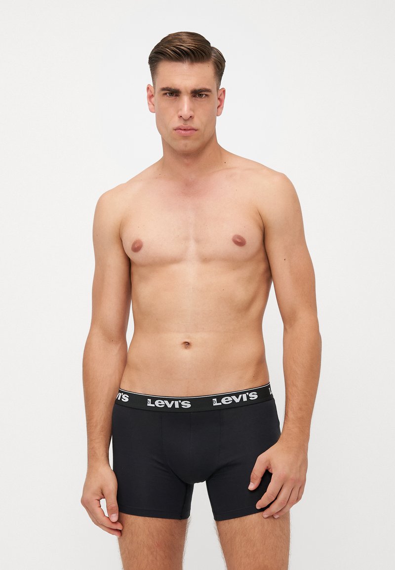 Fekete boxermodel alsónemű, széles elasztikus derékpánttal, amelyen fehér "Levi's" logó található. Az anyag sima tapintású, és testhezálló fazonnal rendelkezik.