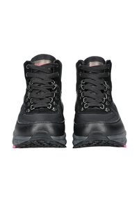 Botas de senderismo negras que combinan materiales de ante y sintéticos, con ojetes metálicos, cordones gruesos y una suela resistente con detalles en rosa.