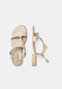 Sandales en cuir beige avec deux larges brides, une bride arrière à la cheville et un talon en bloc texturé bois. Présente un semelle perforée et des accents argentés.