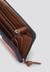 Portefeuille zippé bleu marine avec intérieur en cuir marron. Comprend des emplacements pour cartes, une poche zippée et une tirette en cuir décorative.