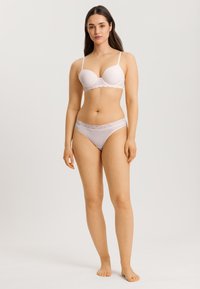 Lichtroze lingerie set met een bh met kantafwerking en verstelbare bandjes, gecombineerd met bijpassende slip met kantaccenten. Soepele textuur.