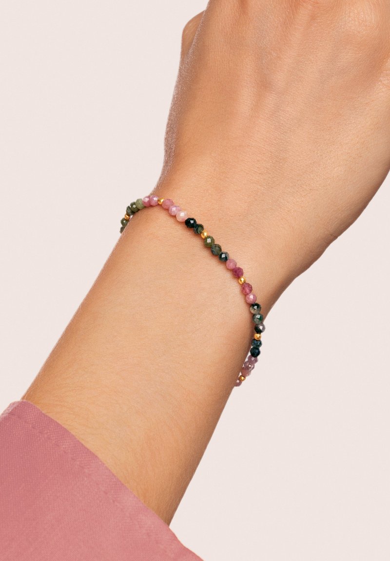 Pulsera de cuentas con piedras semipreciosas de varios colores en diferentes tonalidades, con pequeños detalles en oro, montada sobre una delicada banda elástica.