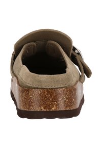 Brun ruskind bag på en sandal med en justerbar rem og en kraftig korksål med en tekstureret overflade.