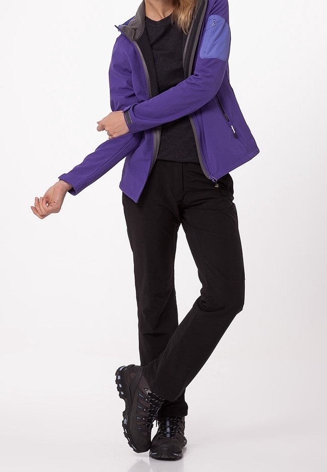 Giacca softshell viola con dettagli grigi, pantaloni neri e scarponi da trekking neri. Caratteristiche includono maniche lunghe e una tasca con zip sul braccio.