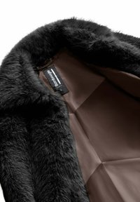 Cappotto in pelliccia sintetica nera con una texture morbida e un interno in raso marrone lucido. Presenta un'etichetta con il nome del marchio "Bamboogie" visibile all'interno.