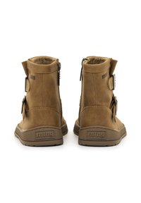 Botas de tobillo marrones de cuero sintético con cremalleras laterales, detalle de hebilla y suelas texturizadas, con un logo en el talón.