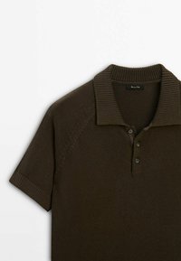 Koszulka polo z krótkim rękawem w ciemnym oliwkowym kolorze, z prążkowanym kołnierzykiem, listwą na trzy guziki i fakturą w dzianinę.