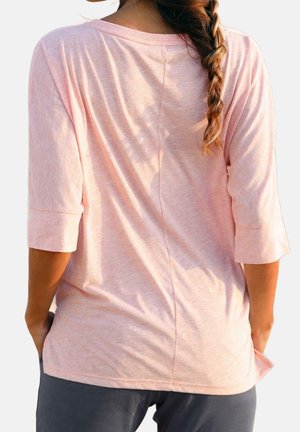 Lichtroze, lange mouw top met een comfortabele pasvorm, textuurstof en opgerolde manchetten. Heeft een achternaad en details aan de zijvent.