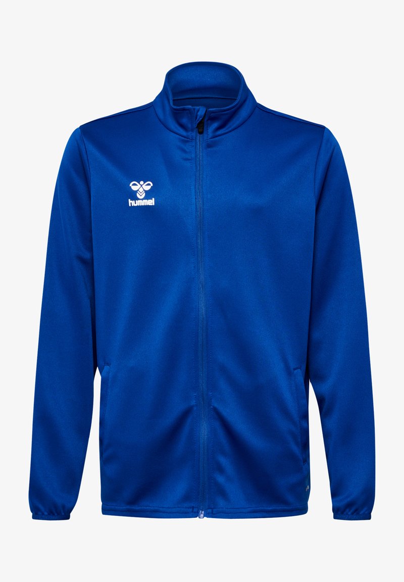 Chaqueta azul con cremallera fabricada en un tejido suave. Presenta un cuello alto, bolsillos laterales y un logo blanco en el lado izquierdo del pecho.