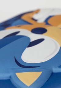 Cuscino in tessuto blu con design di personaggio dei cartoni animati, caratterizzato da grandi occhi bianchi, un accento giallo e una texture liscia.