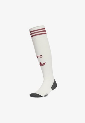 Weiße Kniestrümpfe mit roten Streifen am oberen Ende. Mit kastanienbraunem Text und Logo sowie einer grauen gemusterten Zehen- und Fersenpartie. Weiches Material.