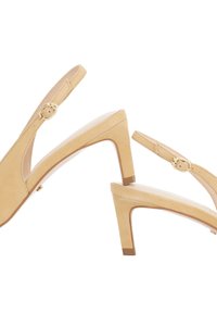 Escarpins beiges à bride arrière en cuir lisse, avec un bout pointu et un talon carré de hauteur moyenne. Accents de boucle en or sur les sangles.