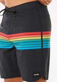 Bañador negro con rayas horizontales de colores en rojo, amarillo, verde y azul. Presenta una cintura con cordón y etiqueta de logo.
