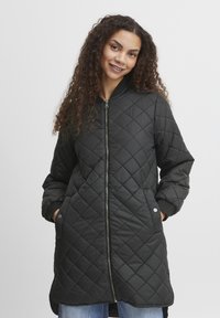 Schwarze, gesteppte lange Jacke mit einem Frontreißverschluss, gerippten Bündchen und seitlichen Taschen. Glatte Textur mit einem Diamantmuster.