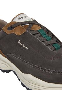Sneaker in suede grigio con dettagli marroni, lacci multicolori e suola in gomma. Include il logo del marchio e dettagli di cucitura lungo i lati.