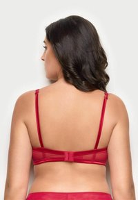 Czerwony przezroczysty biustonosz z regulowanymi ramiączkami, gładką taśmą i zapięciem na haftkę z tyłu, zapewniającym bezpieczne dopasowanie i komfort.