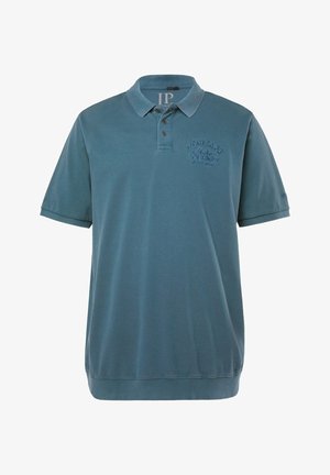 Polo à manches courtes bleu ardoise avec col, trois boutons et texte brodé "Heritage Motor Journey Since 1889" sur la poitrine.