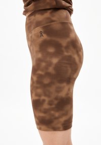 Shorts de vélo à motifs marron en tissu texturé. Présentent une taille haute et un petit logo sur le côté. Fini lisse.