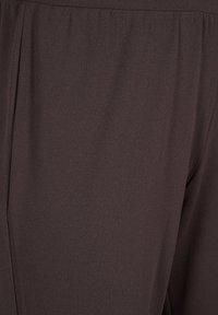 Dark brown trousers made from smooth, lightweight fabric. Features a relaxed fit with side pleats and an elastic waistband.