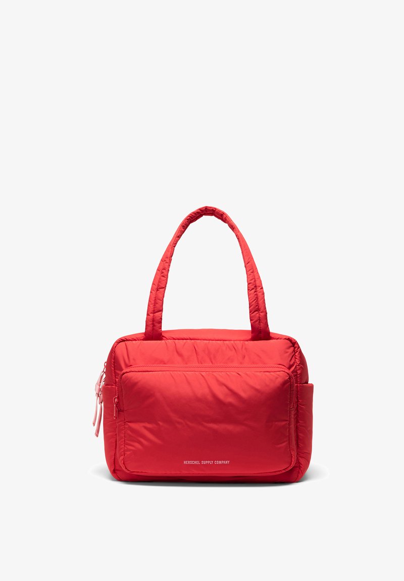Cabas matelassé rouge vif avec deux anses, grande poche zippée sur le devant et poche latérale. Inscription blanche « "Herschel Supply Company" » sur le devant.