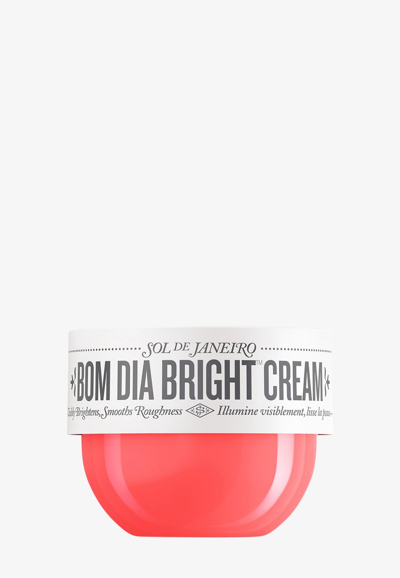 Mały okrągły słoik Sol de Janeiro Bom Dia Bright Cream z białą pokrywką i koralowo-różowym korpusem, używany do rozjaśniania i wygładzania skóry.