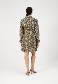 Vestito leopardato con maniche lunghe, vita aderente e orlo dritto, realizzato in tessuto liscio. Abbinato a tacchi aperti.