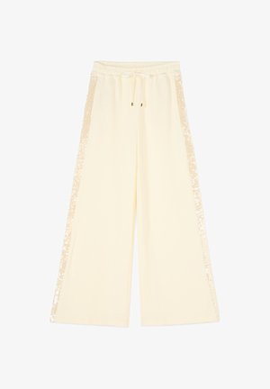 Krémové kalhoty se širokými nohavicemi, elastickým pasem, šňůrkou a flitrovými pruhy na obou stranách.