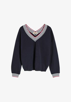 Granatowy sweatshirt z dekoltem w serek, ozdobiony nałożonymi białymi i czerwonymi paskami. Długie rękawy z elastycznymi mankietami oraz ściągaczem u dołu.