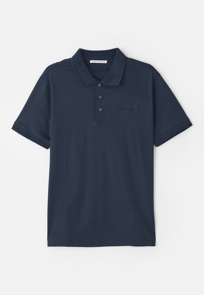 T-paita tummansinisestä puuvillasta, jossa on kolme napinläpeä, lyhyet hihat ja huomaamaton logo rinnassa. Laatupinta.