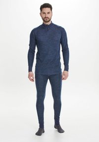 Mörkblå termotopp med halvdragkedja och lång ärm, ihop med matchande åtsittande leggings i mjukt, strukturerat tyg.